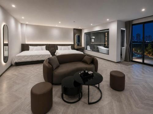 a bedroom with a bed and a couch and a table at B&N HOTEL Hải Tiến in Mỹ Ðuc
