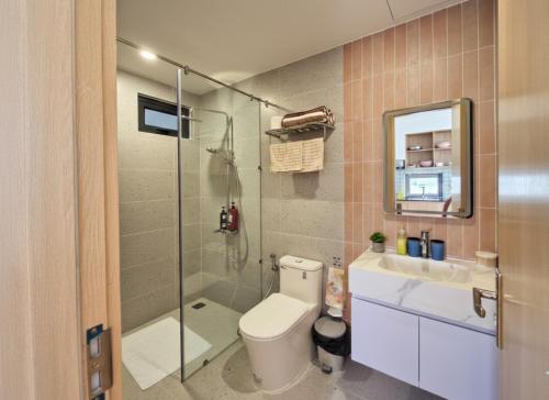 a bathroom with a toilet and a shower and a sink at Seaflow Staycation in Danang