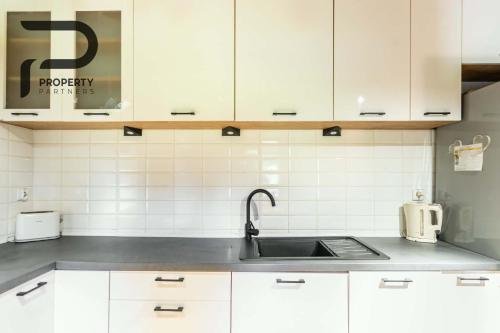a kitchen with white cabinets and a sink at Góralski relaks in Dzianisz