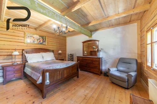 a bedroom with a bed and a chair in a room at Góralski relaks in Dzianisz