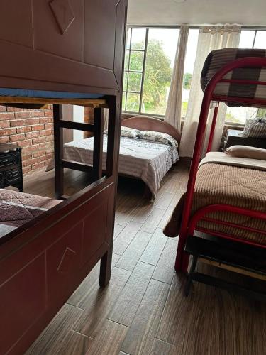a bedroom with two bunk beds and a window at Céntrico con cocina parqueadero e internet in Baños