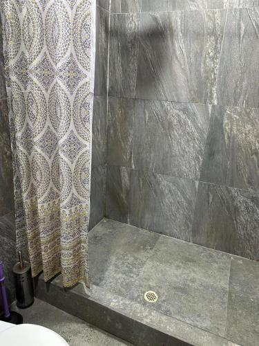 a shower with a shower curtain in a bathroom at Céntrico con cocina parqueadero e internet in Baños
