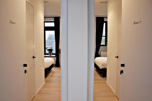 2 Türen in einem Zimmer mit 2 Betten in der Unterkunft B&B VIENNA in Lokeren
