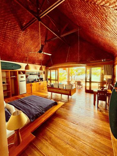 a bedroom with a large bed and a living room at Ombak Biru Resort in Tua Pejat