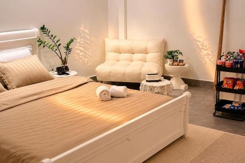 a bedroom with a large bed and a chair at BeHomestay in Hai Phong
