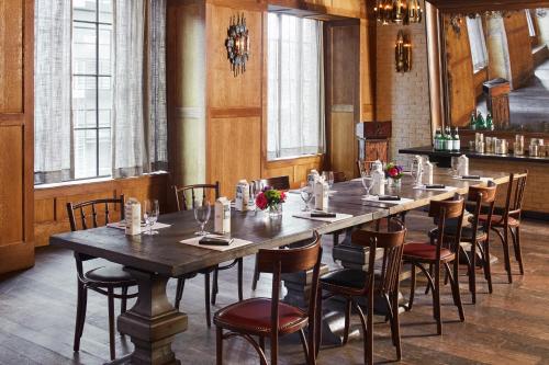 a long table in a room with chairs and a table at The Ludlow Hotel in New York
