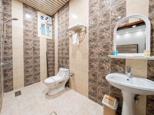 a bathroom with a toilet and a sink at فندق مشارف ابها in Abha