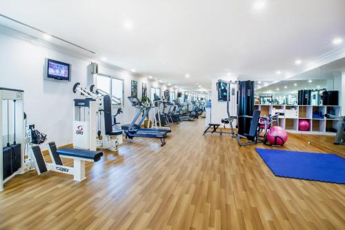 a gym with a row of treadmills and machines at Grand Excelsior Hotel - Bur Dubai in Dubai
