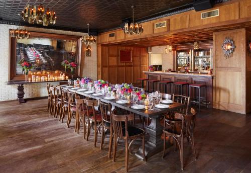 a long dining room with a long table and chairs at The Ludlow Hotel in New York