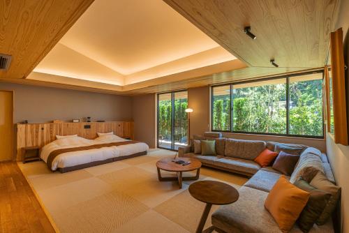 a large bedroom with a bed and a couch at みささ in Kyonan