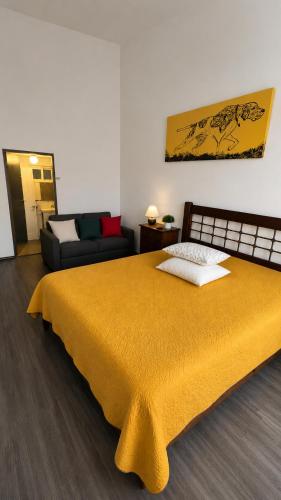 a bedroom with a yellow bed and a couch at Mexican House in Mexico City