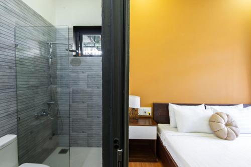 a bathroom with a bed and a glass shower at The Node Homestay & Apartment in Xuan An