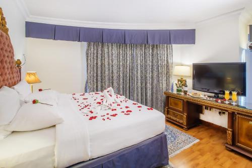 a hotel room with a bed and a flat screen tv at Grand Excelsior Hotel - Bur Dubai in Dubai