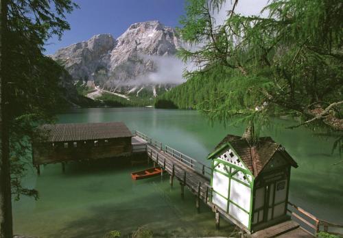 a dock on a lake with a mountain in the background at Hotel Erika in Braies