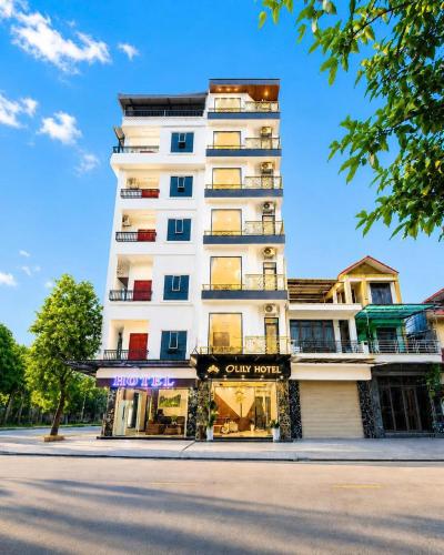 a tall white building with a store on a street at O Lily Hotel in Ninh Binh