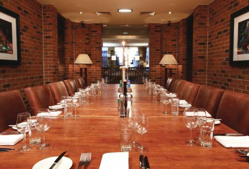 a long table in a restaurant with glasses on it at Hotel du Vin Cheltenham in Cheltenham