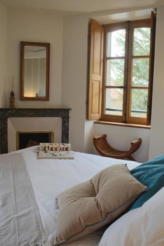 - un lit blanc dans un dortoir doté d'une cheminée dans l'établissement Orangerie Saint Martin, à Mary-sur-Marne