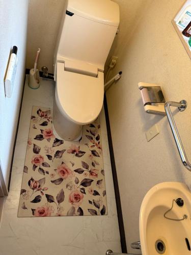 a bathroom with a toilet with a flower tile floor at 安易 旅館1号房间 in Okayama