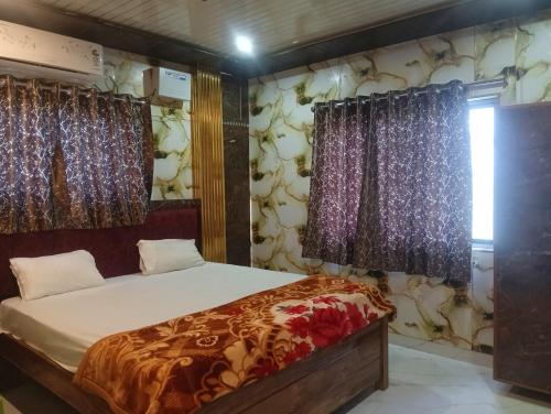 a bedroom with a bed and curtains and a window at Family Hotel Stay In Hotel AV Priya Rajgir in Rājgīr