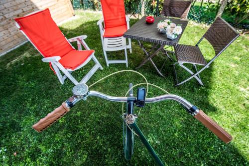 a bicycle parked in a yard with chairs and a table at La Casa di Linda in Mirano