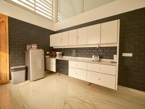 a kitchen with white cabinets and a refrigerator at RB Villa in Indore