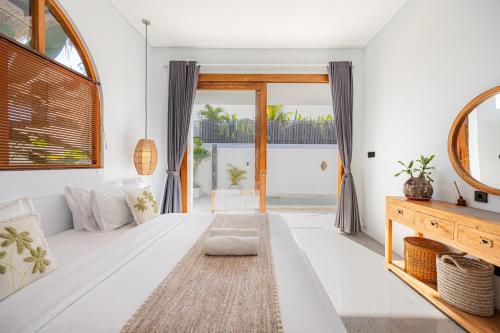a living room with a large bed and a large window at Anatha Villa Uluwatu in Badung