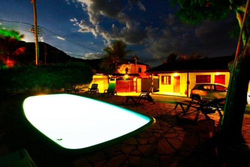 a swimming pool in front of a house at night at Chales Maresias in Maresias