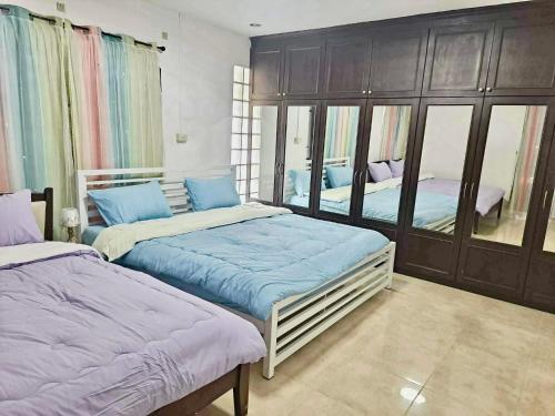 a bedroom with two beds and a mirror at Pani House Hatyai 6 in Hat Yai