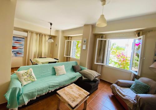 a living room with a green couch and a table at Island Traditional House in Poros