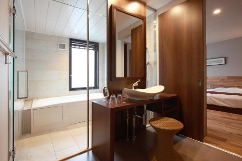 a bathroom with a sink and a shower and a tub at ゆうみ in Kyonan