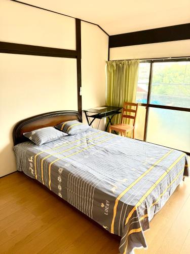 a bedroom with a bed and a table and a window at 安易旅館3号房间 in Okayama