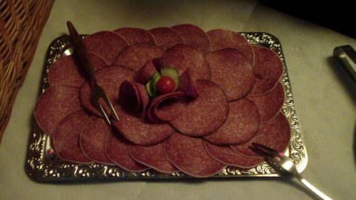 a plate of salami on a table with two chop sticks at Sauerland-Hotel in Essentho
