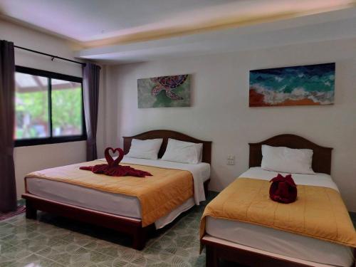 a hotel room with two beds and a window at D.R. Lanta Bay Resort in Ko Lanta