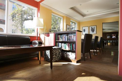 una sala de estar con una mesa y un estante de libros en Strandhotel Margaretha, en St. Wolfgang