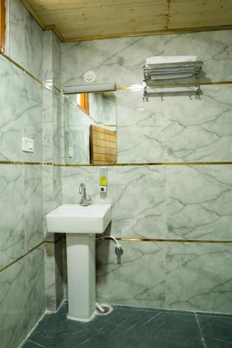 a bathroom with a sink and a mirror at Kabila King Resort in Chakrāta