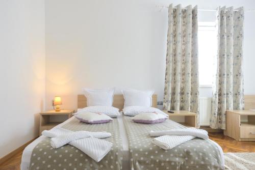 a bedroom with a bed with pillows on it at Pension Verona Centru in Cluj-Napoca