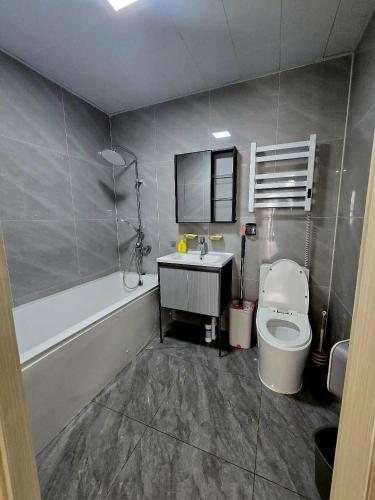 a bathroom with a toilet and a sink and a tub at Arga bilig complex in Ulaanbaatar