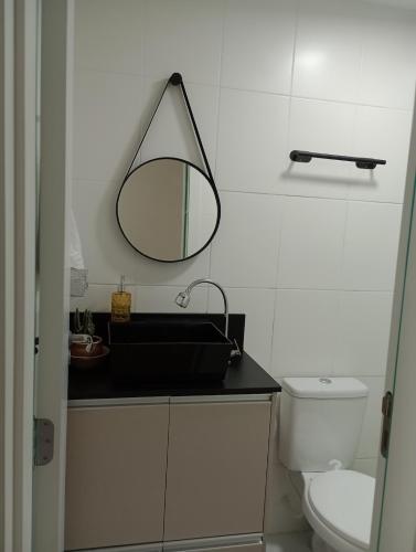 a bathroom with a sink and a mirror on the wall at Apartamento próximo ao Aeroporto e Curitiba in São José dos Pinhais