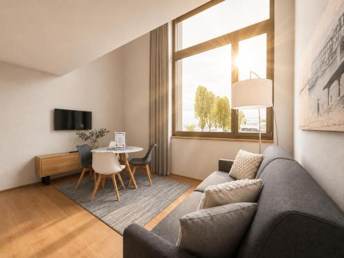 a living room with a couch and a table at LAKE-LOFT APARTMENT's direkt im Hafen in Romanshorn