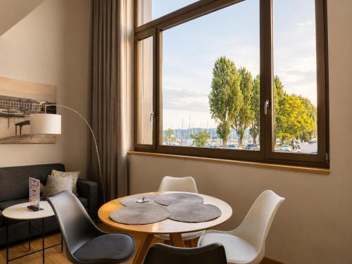 a room with a table and chairs and a window at LAKE-SIDE Fernblick in Romanshorn