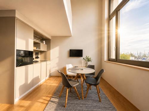 a dining room with a table and chairs and a window at LAKE-SIDE Säntisblick in Romanshorn