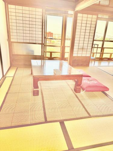 a room with a glass table and a bench at 安易旅館二楼 in Okayama