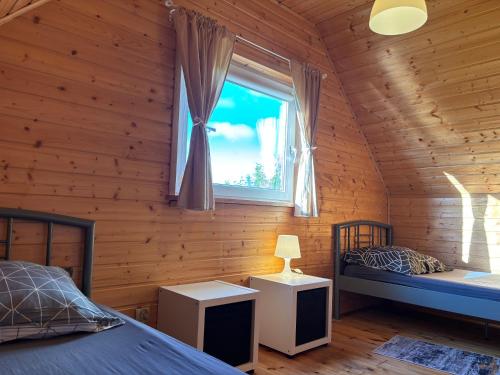 a bedroom with a bed and a window in a log cabin at Domki letniskowe Nadia z podgrzewanym basenem in Władysławowo