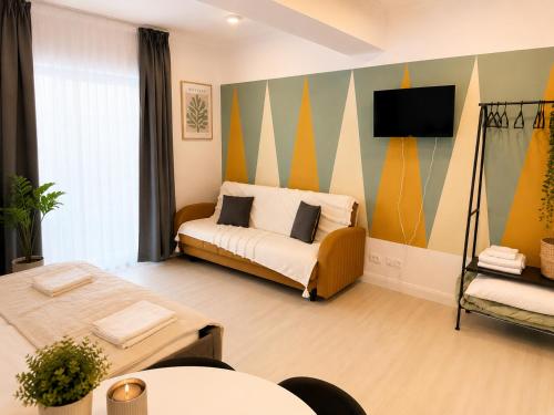 a room with two beds and a tv on a wall at DD Apartments - Iuliu Moldovan in Cluj-Napoca