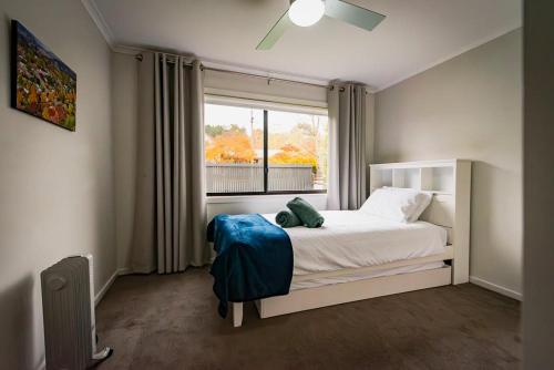 a bedroom with a white bed and a window at High Country on Perkins in Jamieson