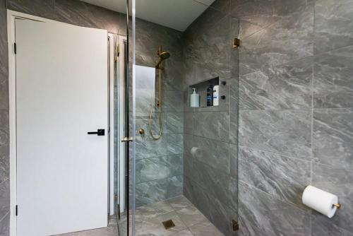 a shower with a glass door in a bathroom at High Country on Perkins in Jamieson