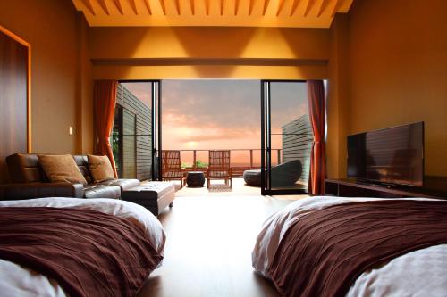 a bedroom with two beds and a flat screen tv at ゆうみ in Kyonan