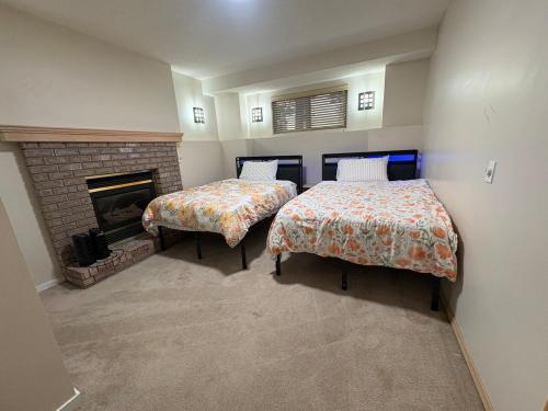 two beds in a room with a fireplace at Lower Suite- 10 minutes away from airport in Calgary