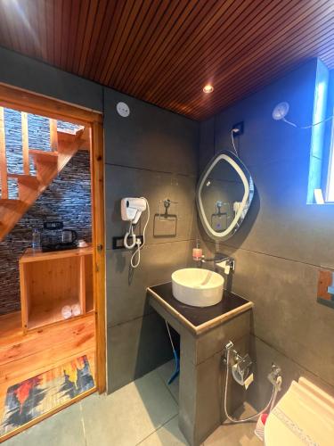 a bathroom with a sink and a mirror at The Pravaas Resort in Barot 