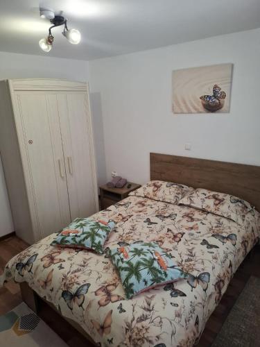 a bedroom with a bed with a floral comforter at Casa de vacanta Sabrina in Gura Humorului